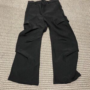 Black baggy slacks with folds. Beautiful peice, the folds make it sit right, so